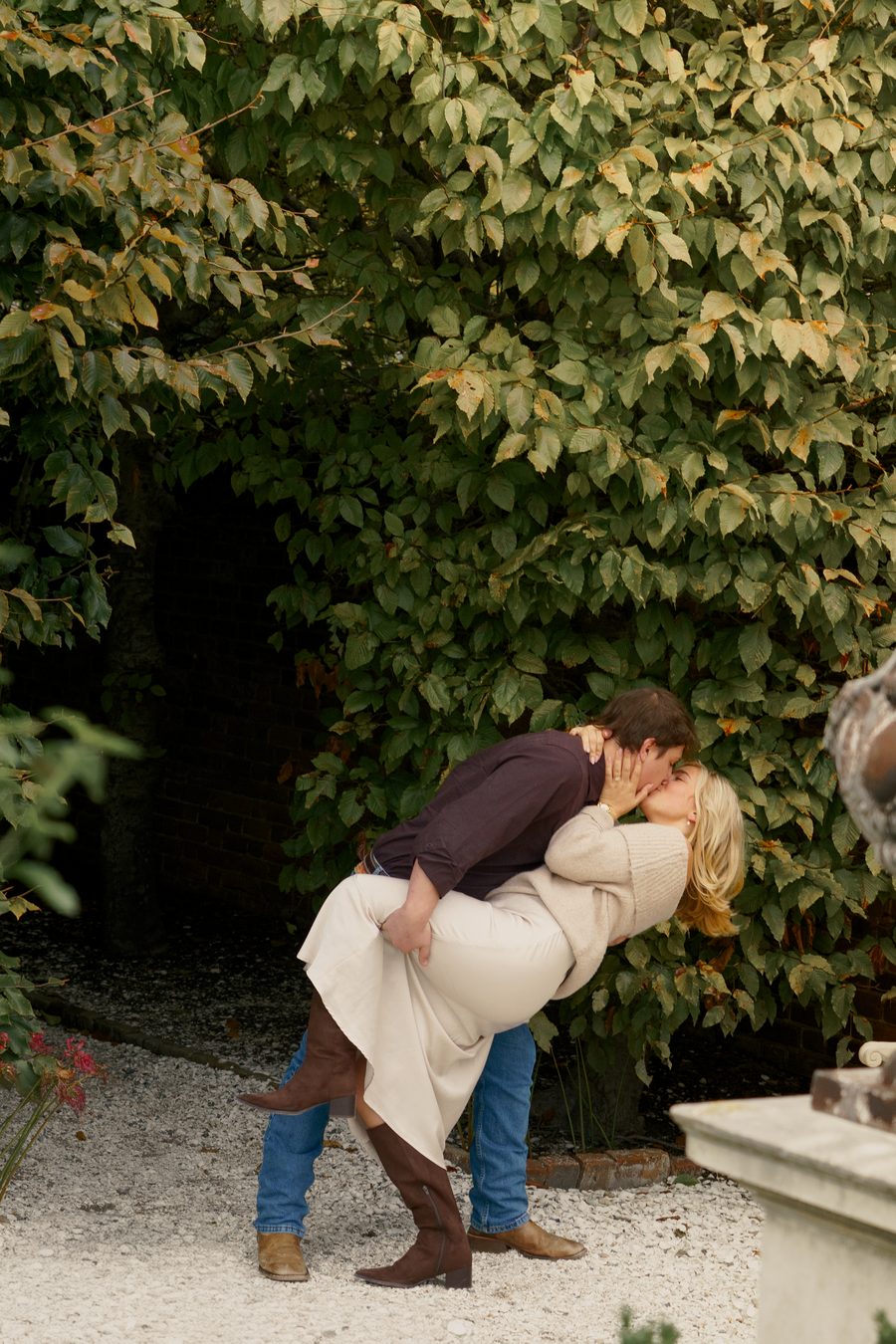 He dips her for a kiss in front of the ivy wall