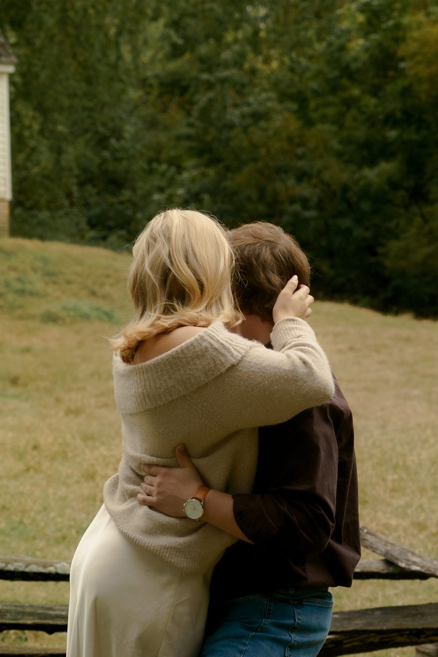 An embrace beside a split rail fence