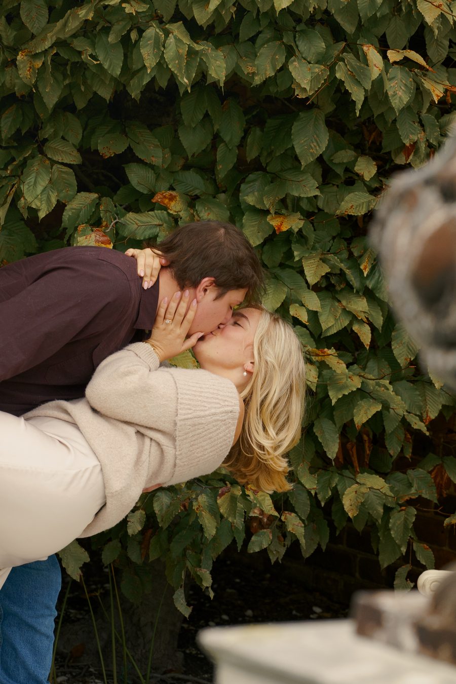 A dip and a kiss against a wall of ivy