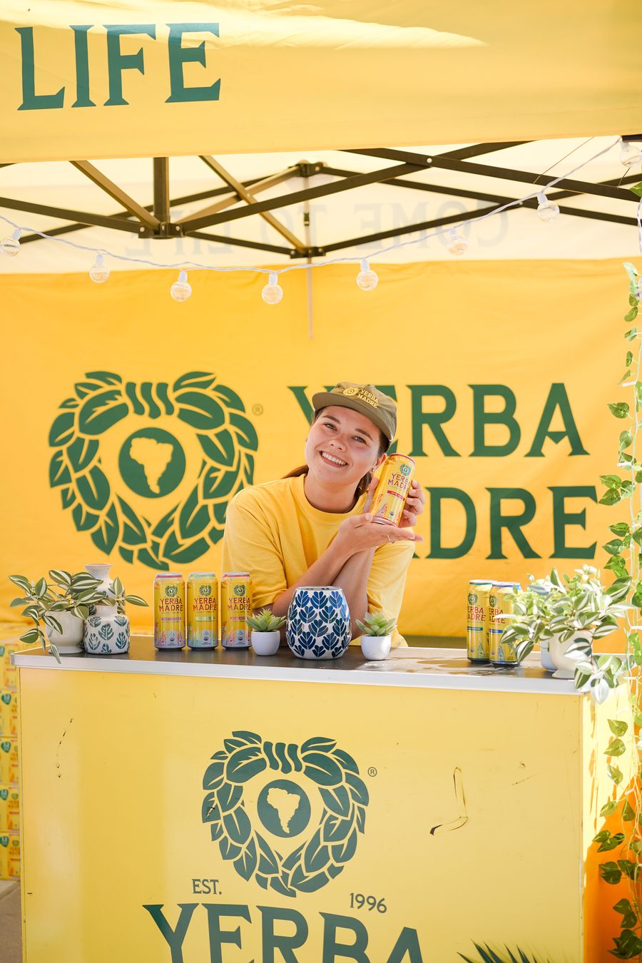 A host pouring drinks at a yellow booth