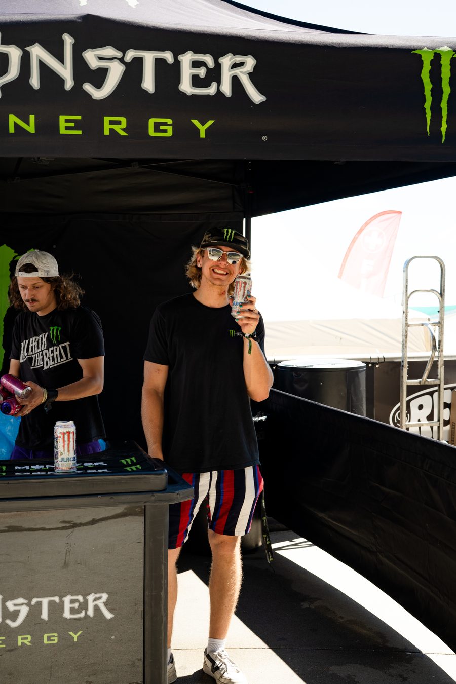 Two people behind a counter at the back of a tent