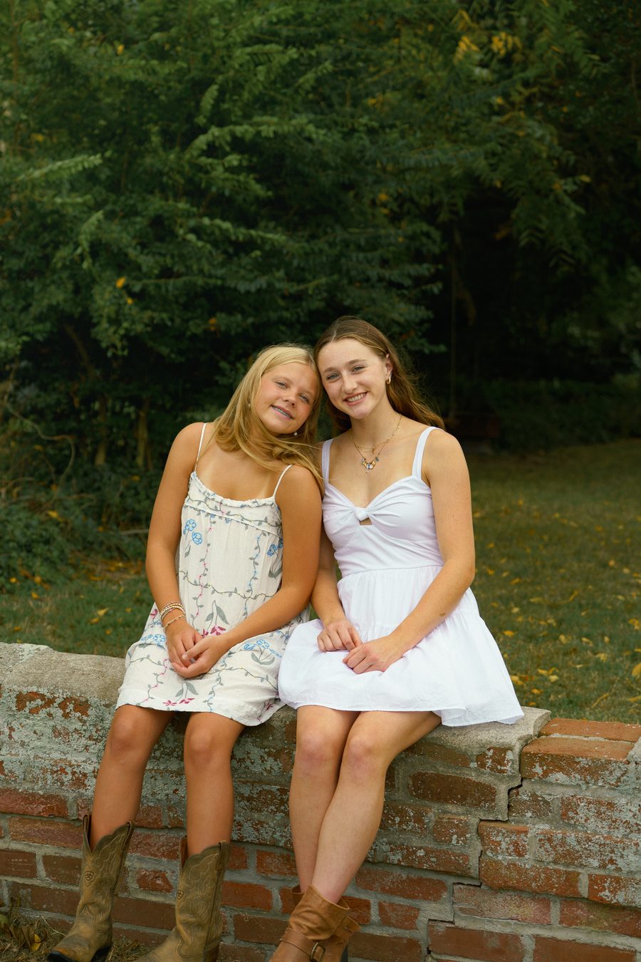 Two friends seated together on a brick wall