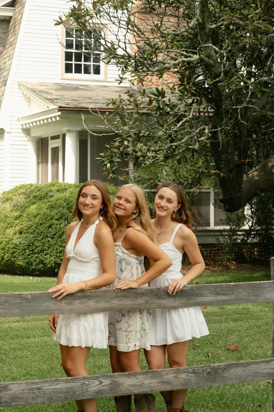 Three friends gathered at a split rail fence