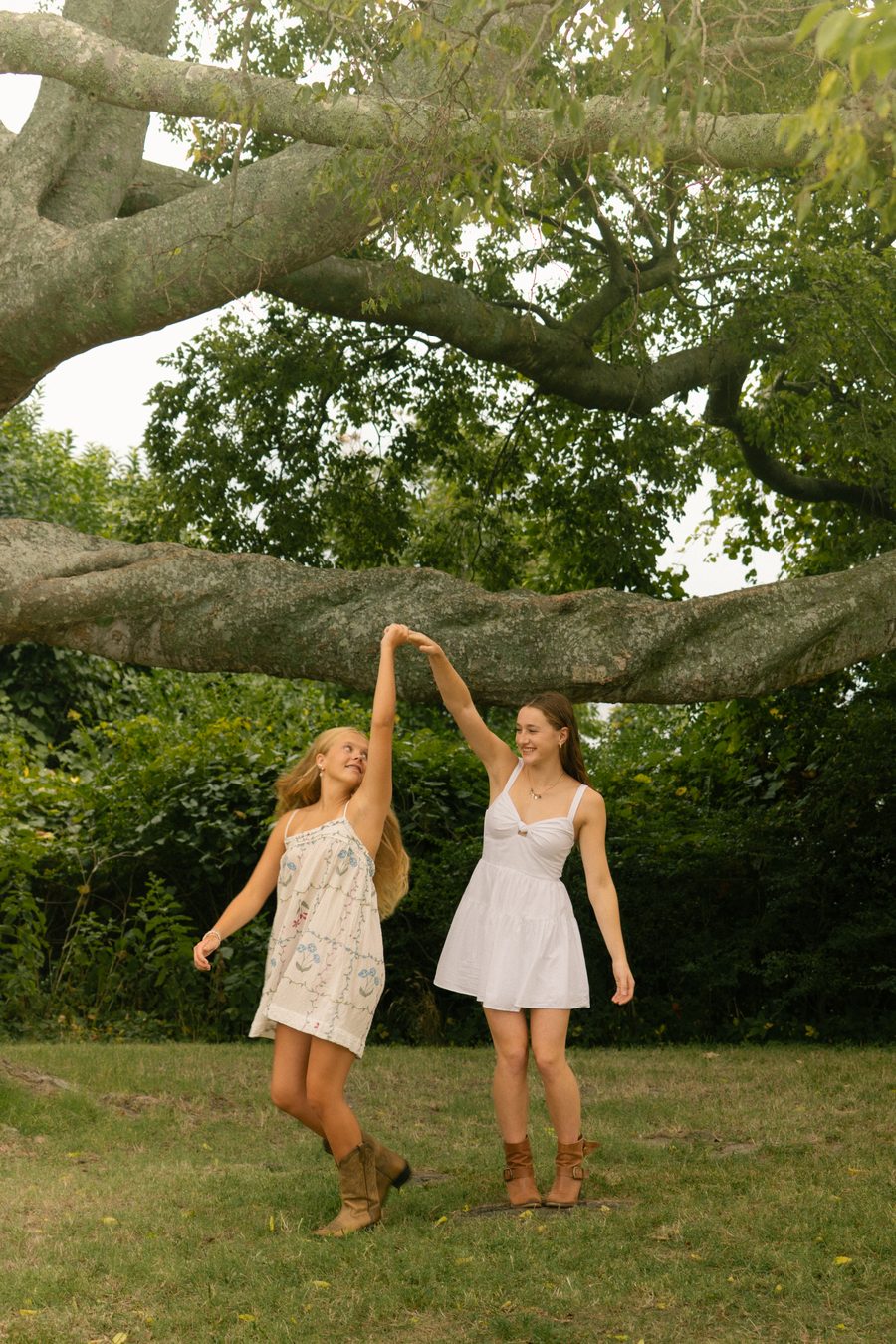 Two friends dancing under a low oak branch