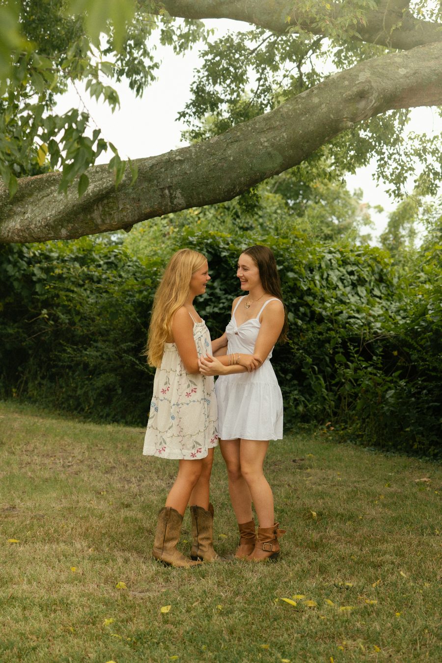 Two friends laughing on an open lawn