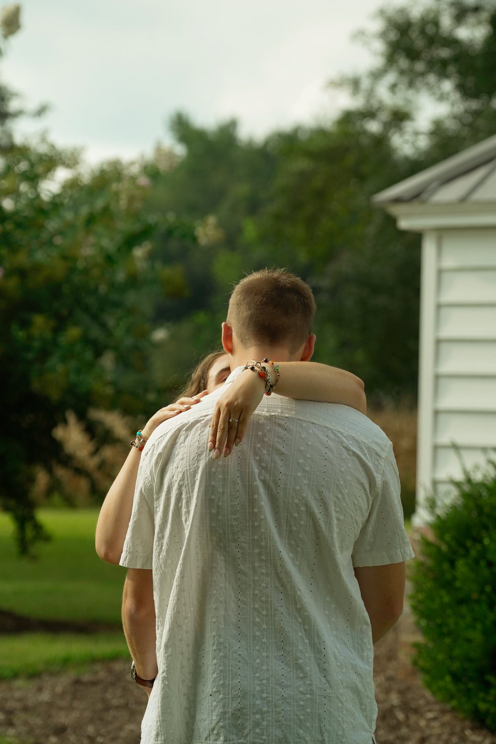 An engagement ring resting on his shoulder