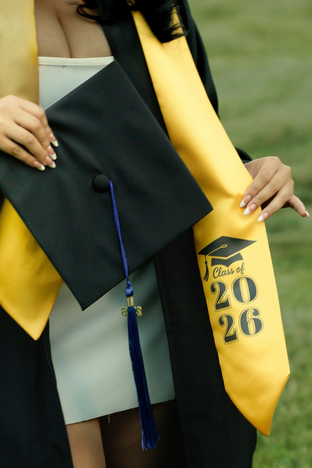 A graduate holding her Class of 2026 sash