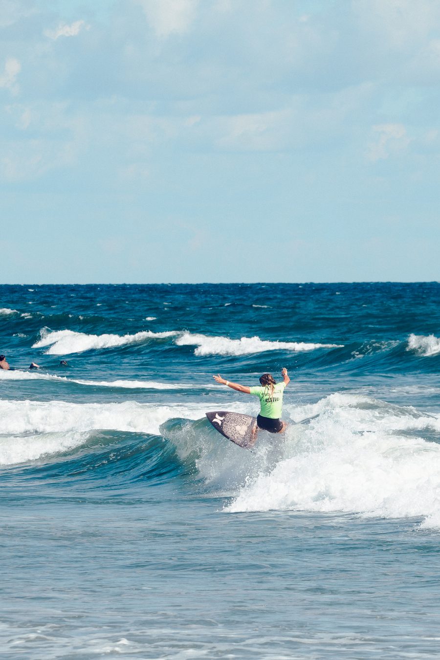 A competitor riding a wave at the Super Girl Surf Pro